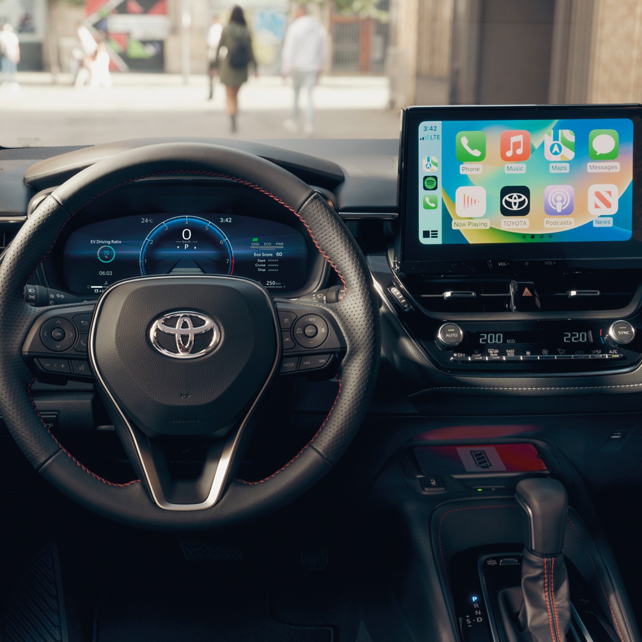 A multimedia touchscreen displays the Apple CarPlay home screen inside a Toyota car with a black dashboard.